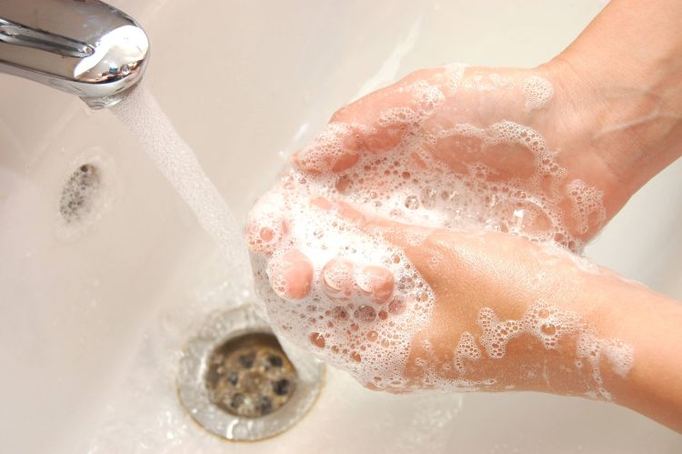 woman washing hand under running water